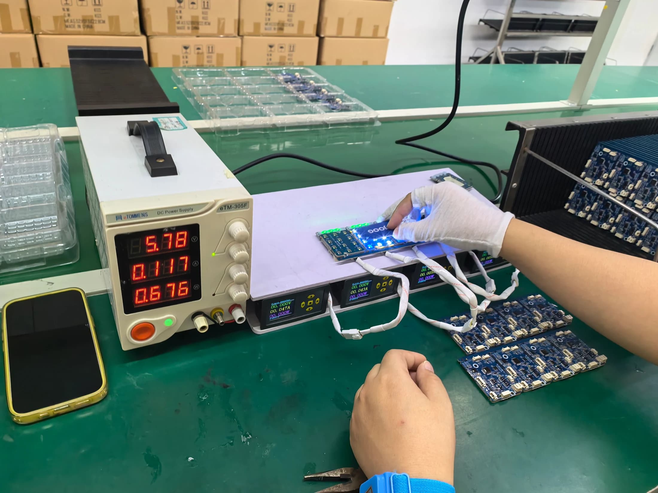 YOUNUO IET operator performing powered functional testing on smart lock PCBA assemblies